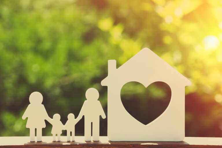 Small model of house and family on blurred background representing owner financing