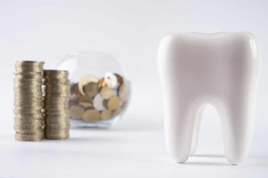 Tooth and piggy box with coins on isolate white background.Financial Concept Dentist Money concept