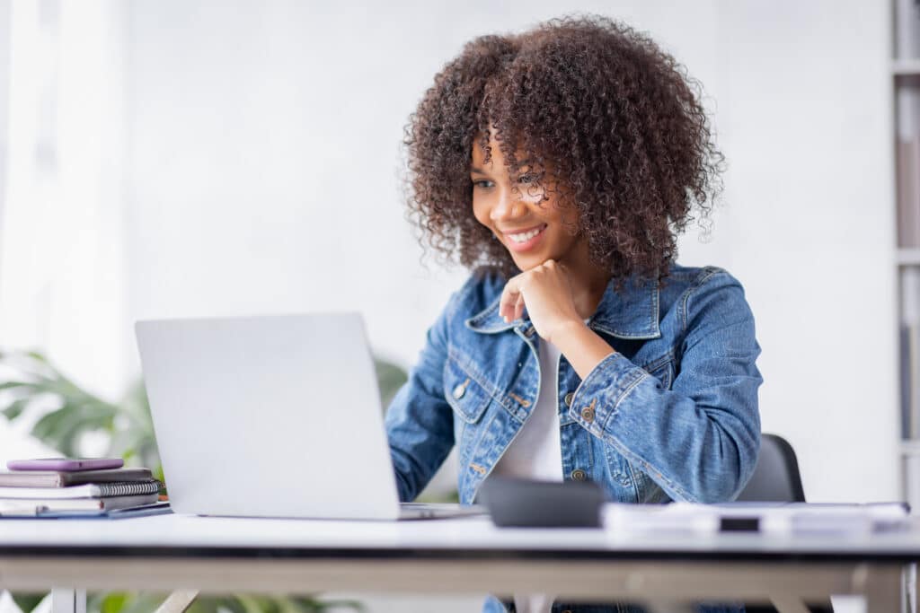 Creative young african american woman working on laptop in her s