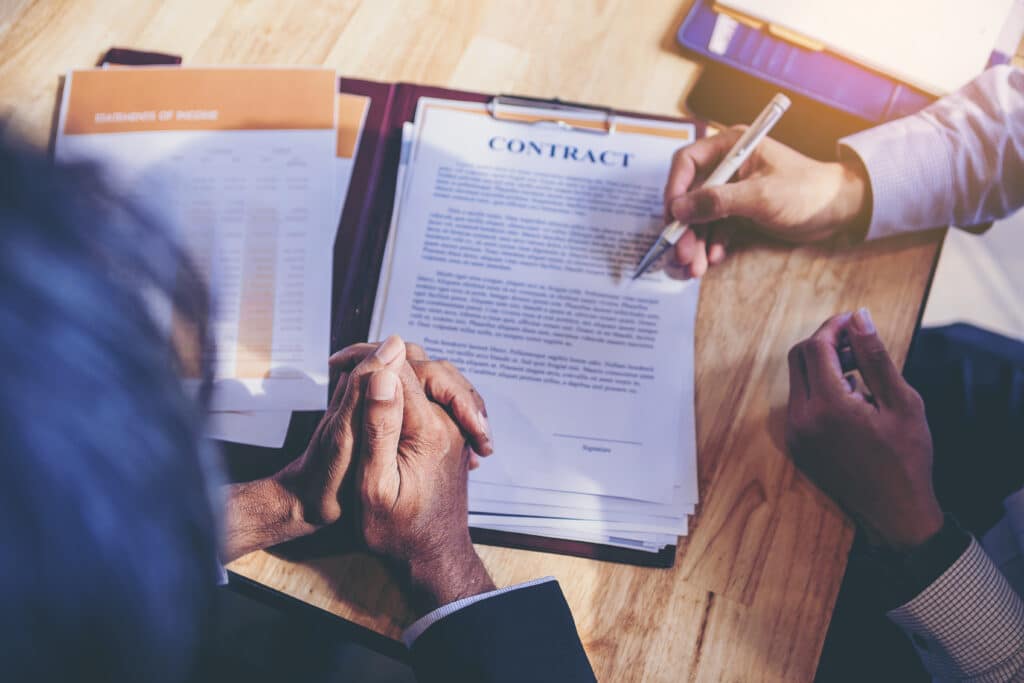 Businessman reading documents at meeting, business partner considering contract terms before signing checking legal contract law conditions