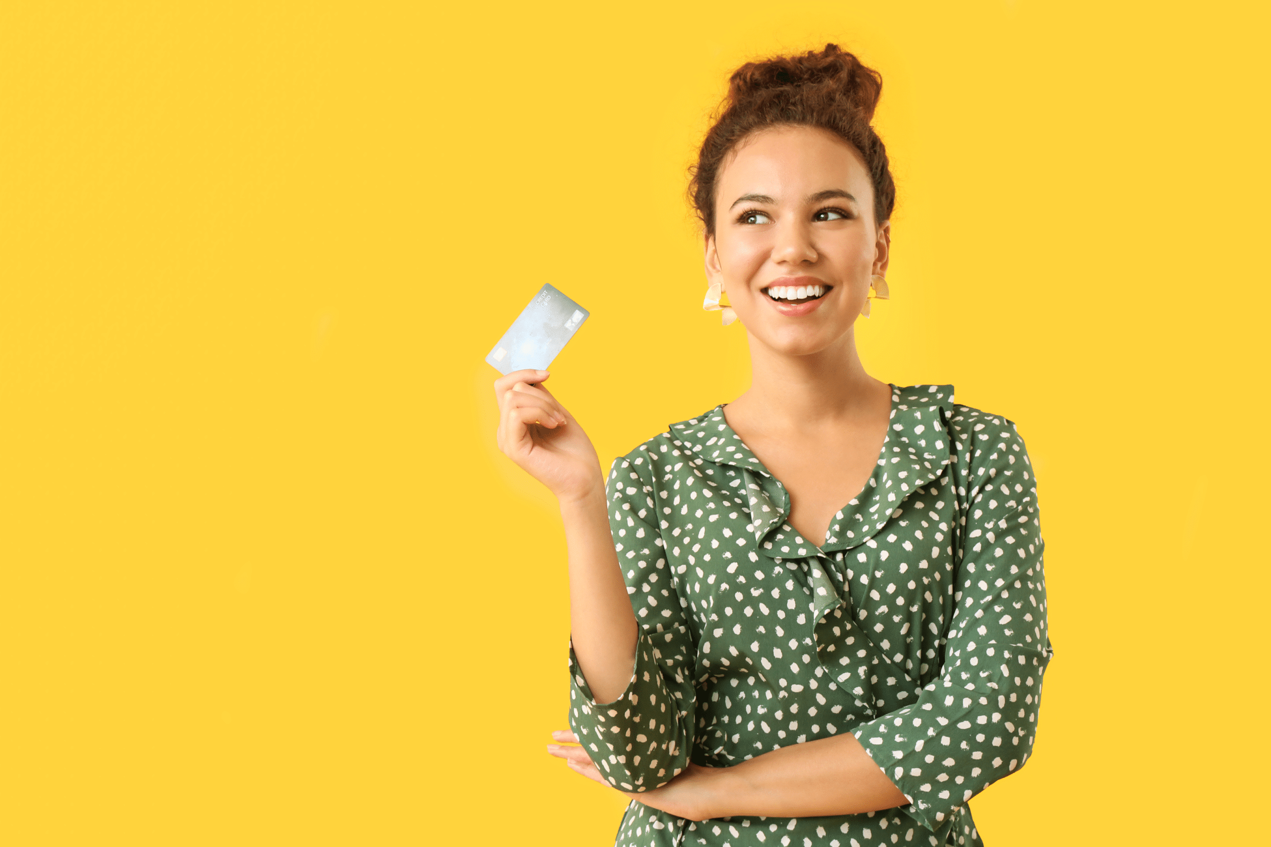 Happy African-American woman with credit card on color background thinking about how to choose a credit card