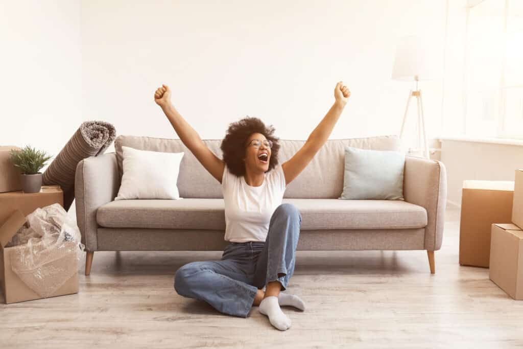 black woman sitting on the floor in her new house because of rapid rescore